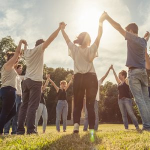 Happy diverse group of people holding hands and raising towards the sky