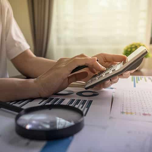 Creditors rely on Unifund and our state of preparedness – Auditing & Validations Close up view of person calculating profits