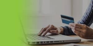 Close up view of a hand making payment using a credit card from the laptop