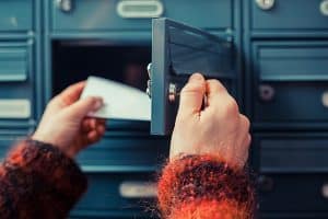 Close up view of hands putting mail inside the locker