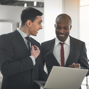 Business professionals having a chat and holding a laptop